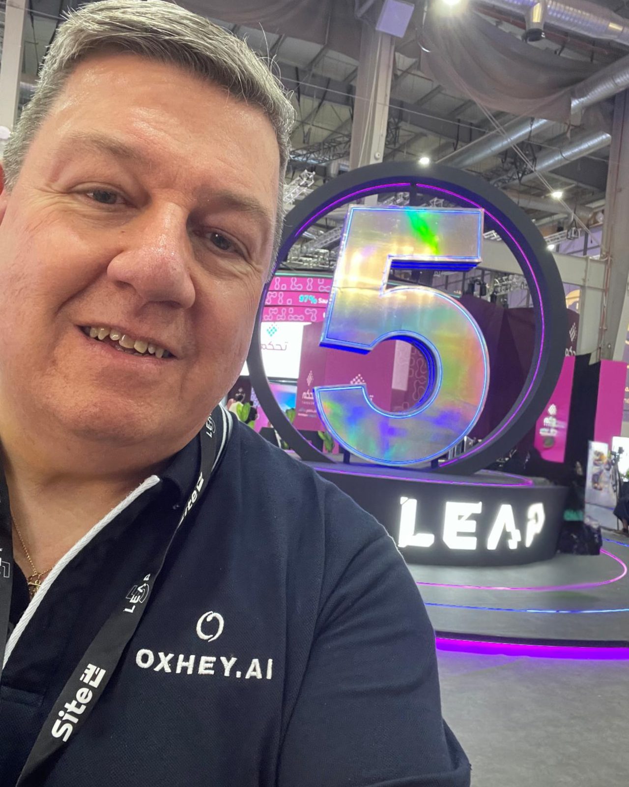 Bushey representative on the LEAP 2026 exhibition floor in Riyadh, beside the illuminated LEAP fifth-anniversary installation.